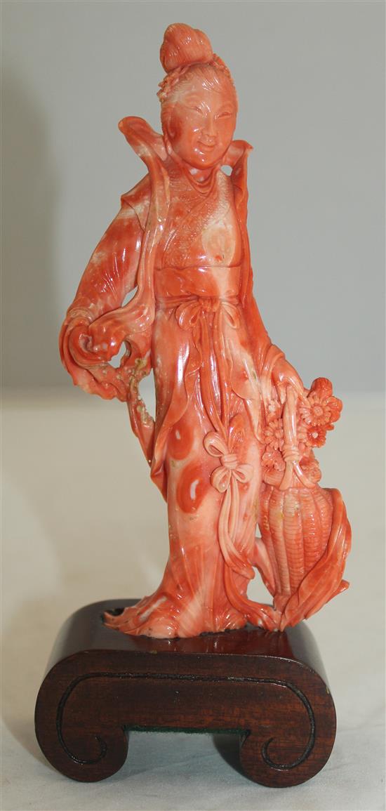 A Chinese coral figure of a beautiful lady holding a basket of flowers, 17.5cm incl. wood stand
